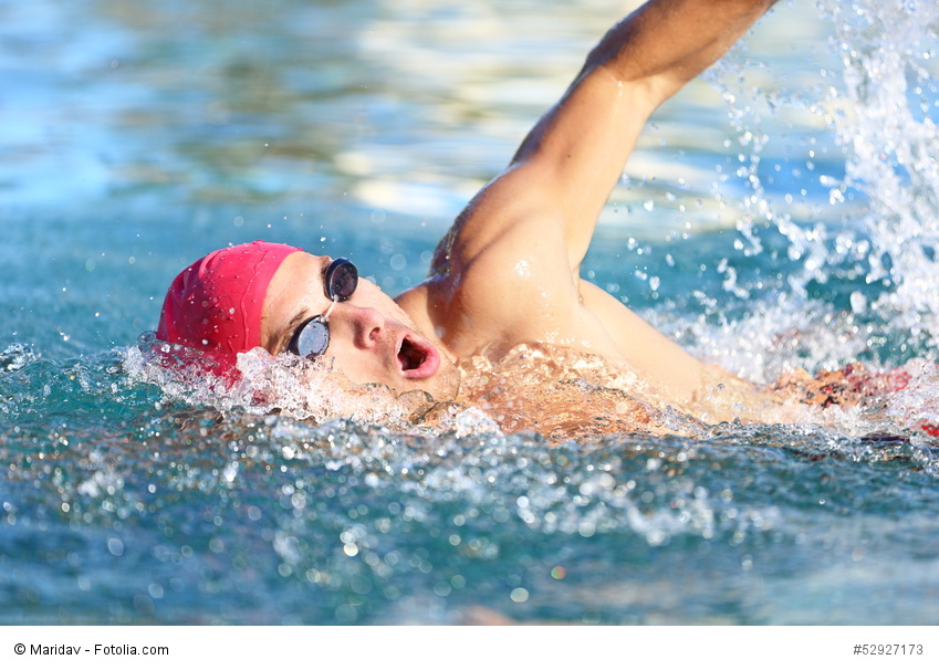 Man swimmer swimming crawl in blue water